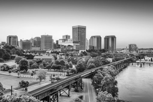 black and white richmond skyline photo with train tracks and james river in foreground.