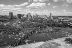 aerial photo of richmond virginia and train track going across the james river in black and white